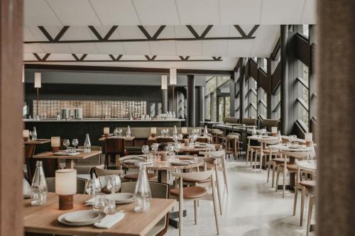 an empty restaurant with wooden tables and chairs at Hagastrand, Autograph Collection in Solna