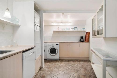a white kitchen with a washing machine in it at FY385-Nyborg-Kronprinsensgade-1-st in Nyborg