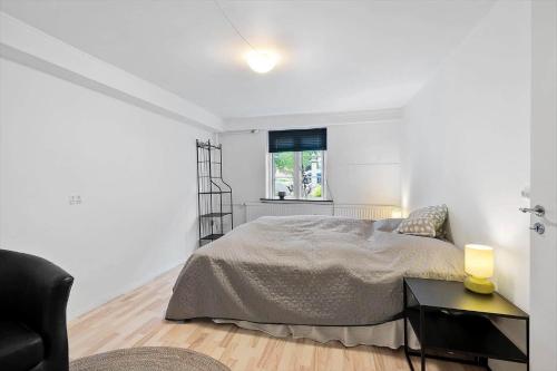 a white bedroom with a bed and a window at FY385-Nyborg-Kronprinsensgade-1-st in Nyborg