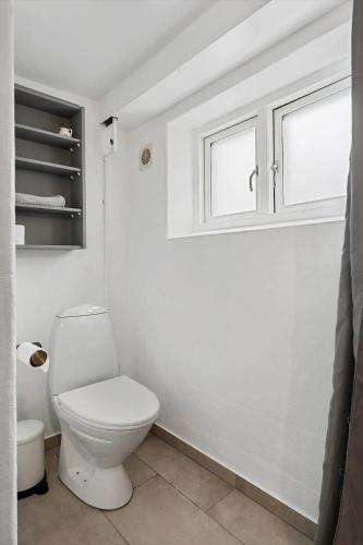 a white bathroom with a toilet and a window at FY385-Nyborg-Kronprinsensgade-1-st in Nyborg