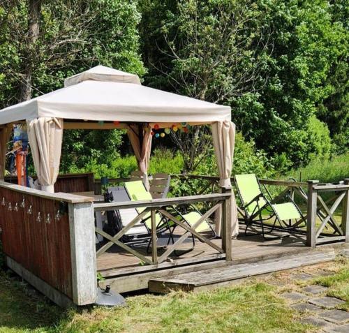 a wooden deck with a gazebo and chairs at KRO414-Loenashult-Norra-Ebboen-1 in Tvetaryd