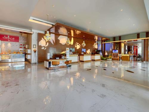 a shopping mall with a large lobby with a store at Novotel Bengaluru Outer Ring Road in Bengaluru