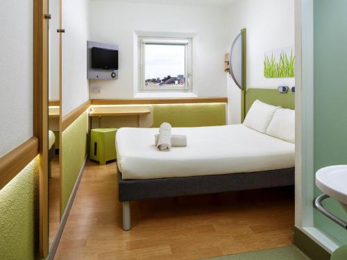 a hotel room with a bed and a sink at ibis budget London Hounslow in Hounslow