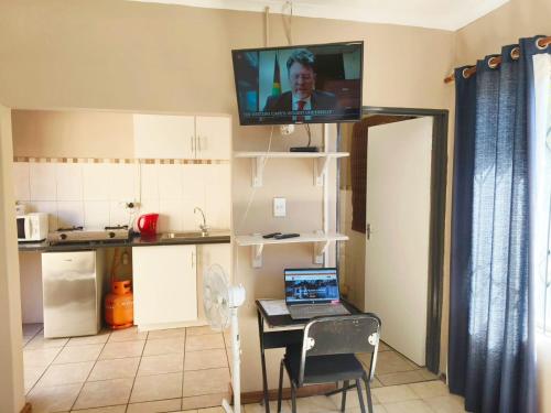 a kitchen with a table with a laptop on it at Tokelo Guesthouse Emalahleni in Witbank