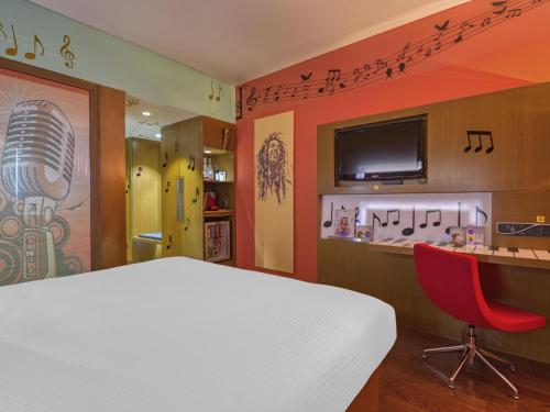 a bedroom with a white bed and a red chair at Novotel Bengaluru Outer Ring Road in Bengaluru