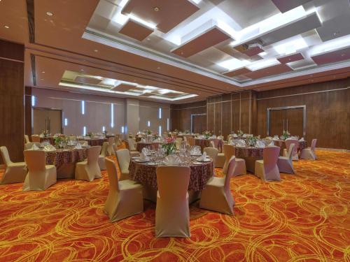 a banquet hall with tables and chairs in a room at Novotel Bengaluru Outer Ring Road in Bengaluru