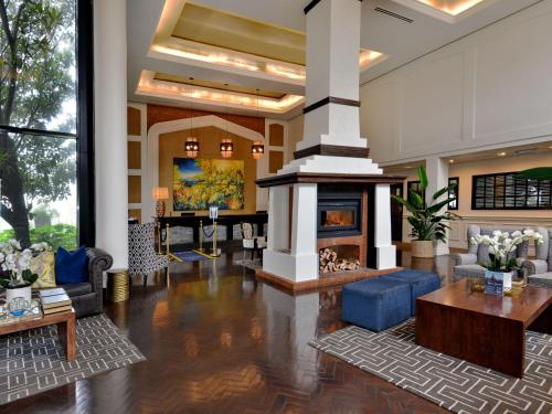 a lobby with a living room with a fireplace at ANEW Hotel Hilton Pietermaritzburg in Hilton