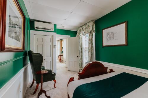 a green bedroom with a bed and a chair at The Underwood-Hale House in Providence