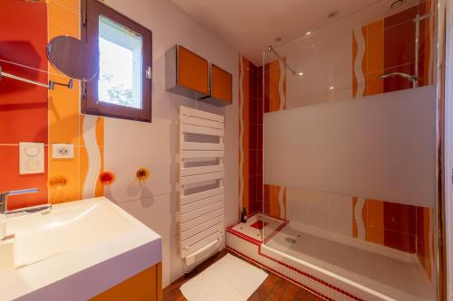 a bathroom with a sink and a shower and a tub at La Jolie Niortaise - Avec piscine in Niort