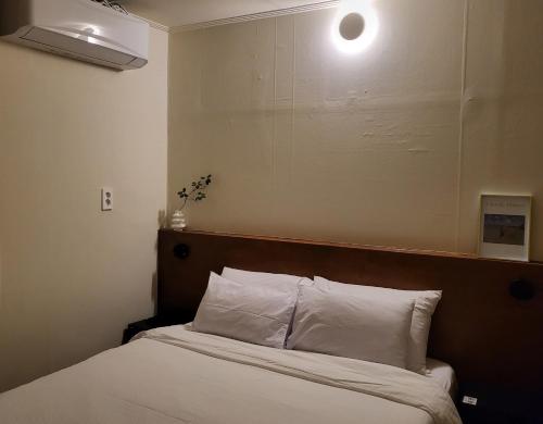 a bed with white pillows and a light above it at jeonju hotel book and type in Jeonju