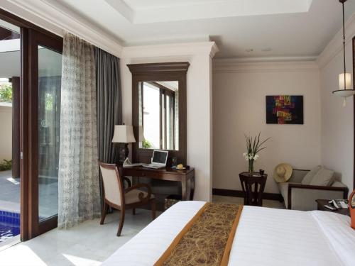 a hotel room with a bed and a desk at Pullman Sanya Yalong Bay Villas & Resort in Sanya