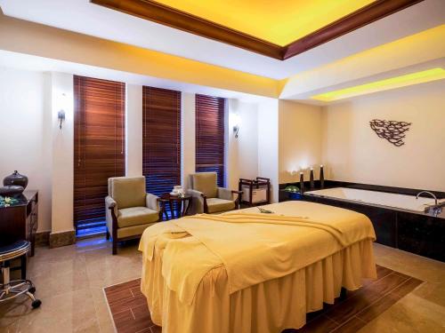 a hotel room with a bed and a bath tub at Pullman Sanya Yalong Bay Villas & Resort in Sanya