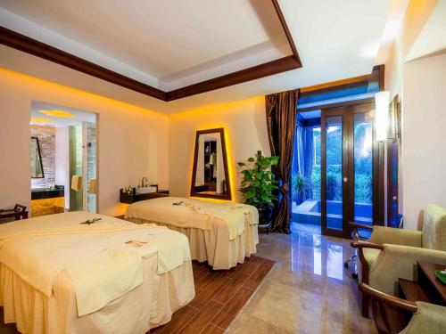 a hotel room with two beds and a mirror at Pullman Sanya Yalong Bay Villas & Resort in Sanya