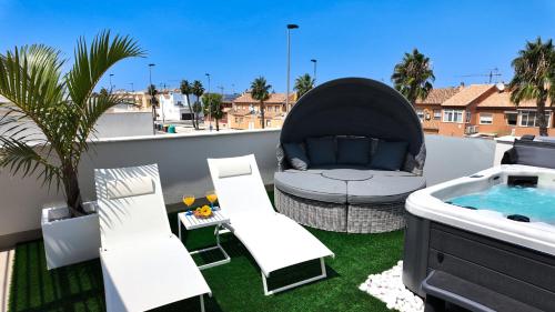 a patio with a tub and a couch on a balcony at Villa Estrella del Mar in San Pedro del Pinatar