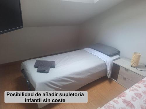 una piccola camera da letto con un letto con lenzuola bianche di Aldea Bricia 6 a Posada de Llanes