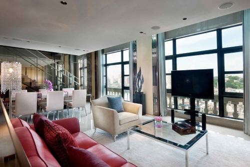 a living room with a couch and a tv and a table at Sofitel Macau At Ponte 16 in Macau