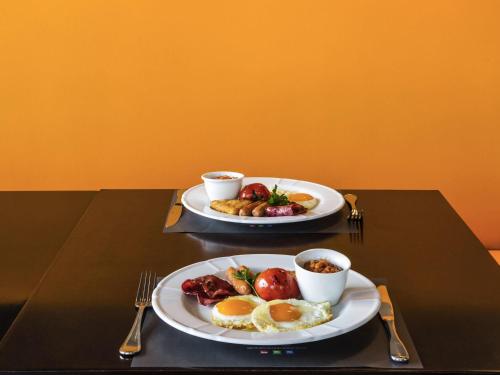 two plates of food on a table with two cups of coffee at ibis Deira Creekside Dubai in Dubai