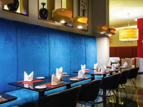 a row of tables in a restaurant with napkins at ibis Mall Avenue Dubai in Dubai