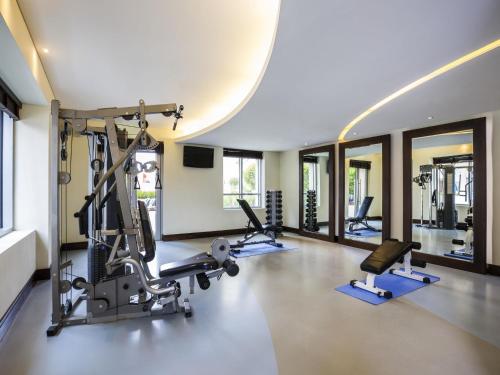 a gym with several treadmills and elliptical machines at Novotel Deira Creekside Dubai in Dubai