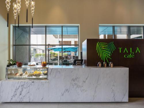 a bakery with a counter with food on it at Novotel Deira Creekside Dubai in Dubai