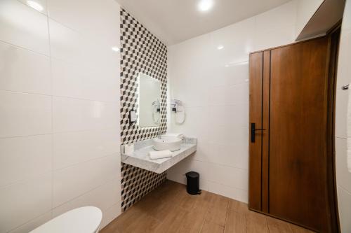 a bathroom with a sink and a toilet and a mirror at Hotel Aferni in Agadir
