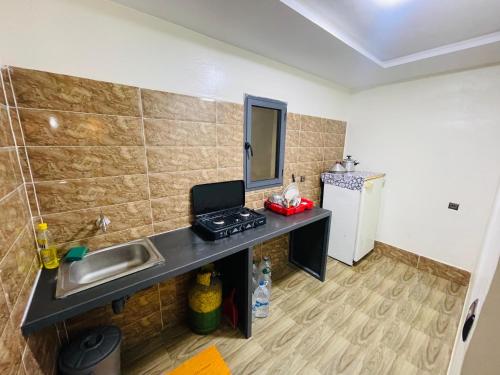 a small kitchen with a sink and a refrigerator at Luxury apartement 3 in laayoune in Oulad Akkou