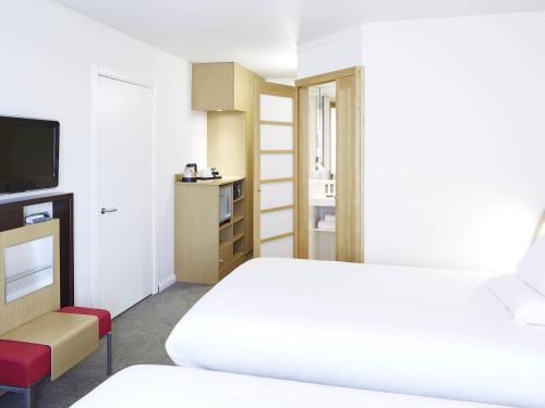 a hotel room with a bed and a television at Novotel Liverpool Centre in Liverpool