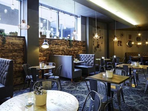 a restaurant with tables and chairs in a room at Novotel Liverpool Centre in Liverpool