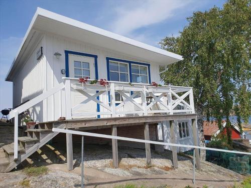 a small white house with a large deck at BOH668-Kloevedal-Bjoerholmen-81 in Björholmen