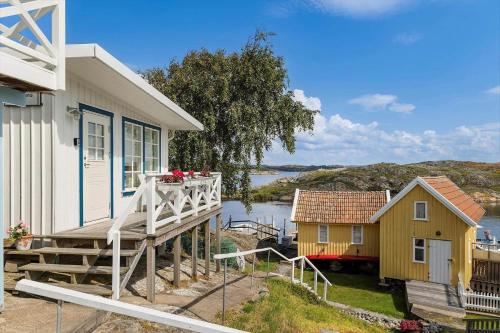 a house with a deck next to a body of water at BOH668-Kloevedal-Bjoerholmen-81 in Björholmen