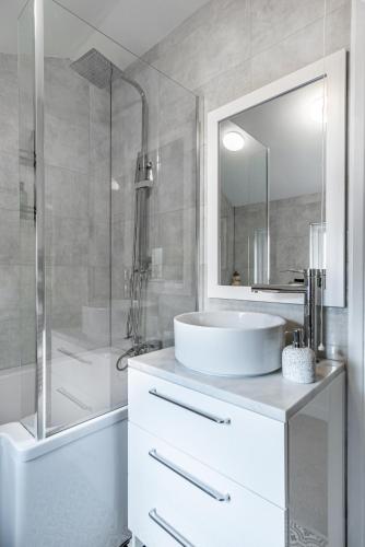 a white bathroom with a sink and a shower at 5BR - House - Hot Tube - Airport - A38-A50 - Parking in Burton upon Trent