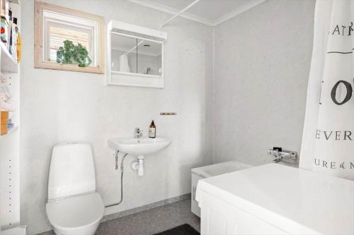 a white bathroom with a sink and a toilet at STO728-Rimbo-Oesterledingevaegen-70 in Länna