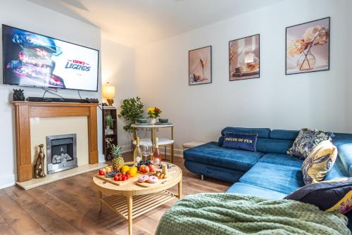 a living room with a blue couch and a tv at 5BR - House - Hot Tube - Airport - A38-A50 - Parking in Burton upon Trent