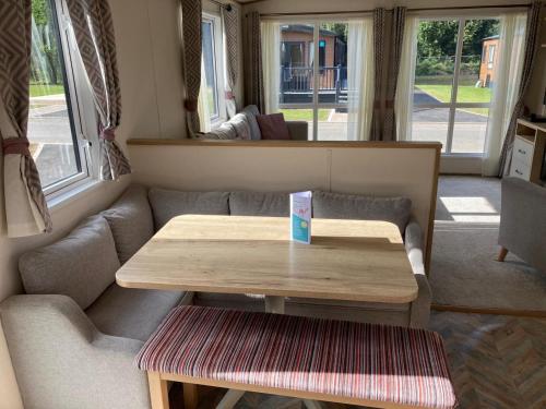 a living room with a table and a couch at Rejuven8 Rentals - Kingfisher Caravan Park - Ingoldmells in Ingoldmells
