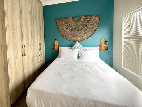 兰格班Casa del Mar - Huisie by die See的卧室配有白色床和蓝色墙壁