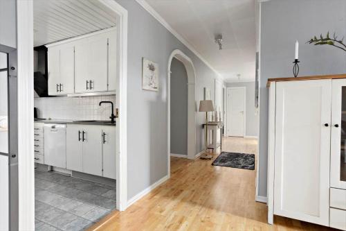 an open kitchen with white cabinets and a hallway at KAL660-Alsterbro-Oxhagsvaegen-22 in Alsterbro
