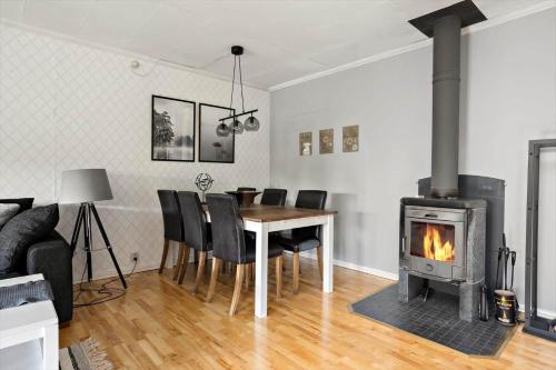 a living room with a table and a fireplace at KAL660-Alsterbro-Oxhagsvaegen-22 in Alsterbro