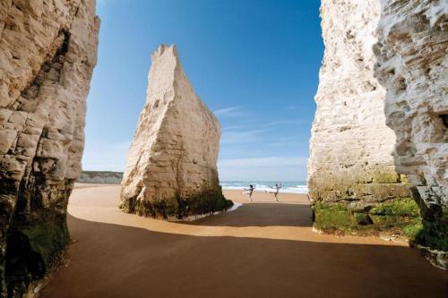 a view of the beach from between two large rocks at Margate Apartment by The Sea 5 minutes to beach and dreamland in Margate