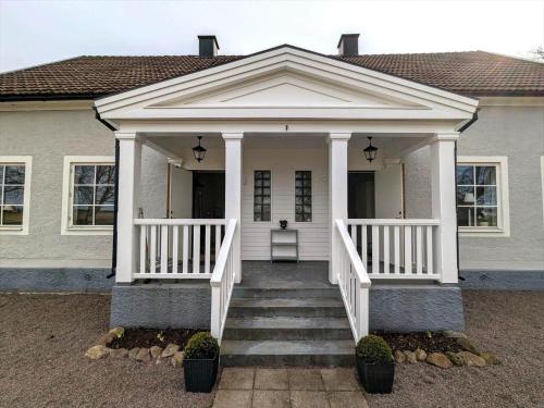 a white house with a white porch and stairs at OGO781-Mjoelby-Norrby-Naesloesegard-1 in Mjölby
