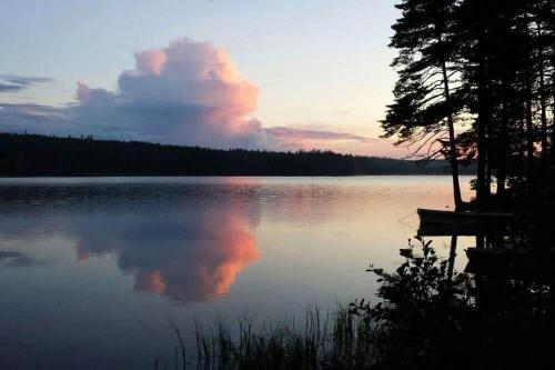 a sunset on a lake with a boat in the water at ORE758-Ramsberg-Persbovaegen-18 in Ramsberg