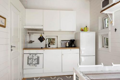 a kitchen with white cabinets and a white refrigerator at BOH779-Stillingsoen-Asarna-121 in Åsarna