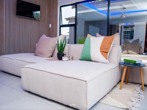 a couch with pillows on it in a living room at Overflow Accommodation Lodge in De Hoop