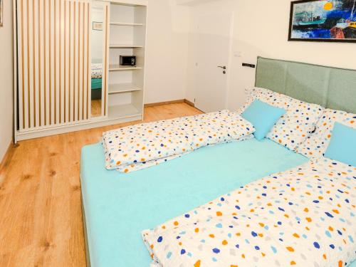 a bedroom with a blue bed with pillows at Modern Apartment with Terrace -15 min to Airport, Free On-Site Parking in Prague