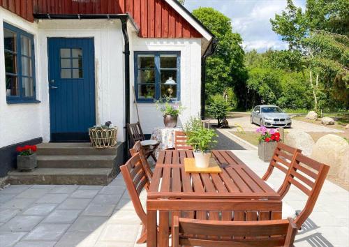 a wooden table and two chairs in front of a house at SKA711-Simrishamn-Lugnadalsvaegen-1 in Baskemölla