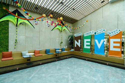 成都市にあるEVEN Hotel Chengdu Jinniu by IHGの椅子と新しい看板のあるプールのあるロビー