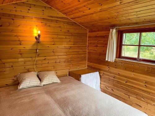 a bedroom with a bed in a wooden room at KRO771-Russby-Rungebacken-Uddeboda-3 in Piggaboda