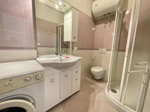 a white bathroom with a sink and a toilet at Lovely flat with sunny terrace in Porto Santa Margherita di Caorle
