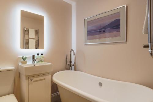 a white bathroom with a tub and a sink at Tyson Place, 2 bed Renovated Apartment, Ambleside in Ambleside