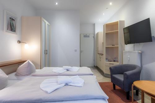 a hotel room with two beds and a chair at Aparthotel Seepanorama in Mirow