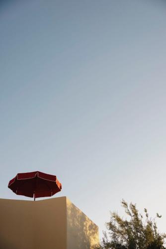a red umbrella sitting on top of a building at Neema Maison Finikia Santorini in Oia